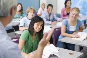 high school students listening to teacher in classroom